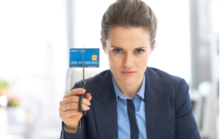 Woman cutting credit card with scissors